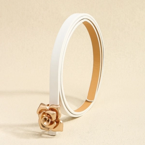 Close-up of white leather skinny belt featuring a 3D gold rose metal buckle detail