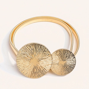 Dettaglio cintura elastica dorata con fibbie metalliche a doppia texture a raggiera