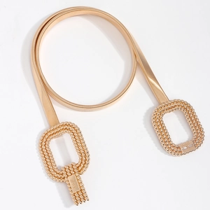 Détail de la ceinture chaîne dorée avec boucles tressées et plaques métalliques gravées