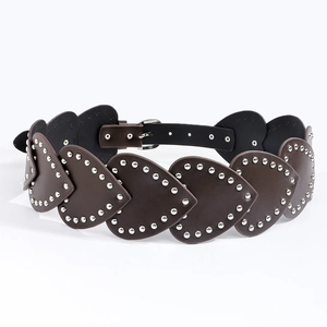 Détail de ceinture vintage en cuir marron avec des cœurs et des clous argentés punk