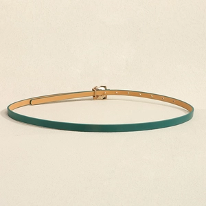 Close-up of thin dark green belt with elegant gold floral buckle and adjustable eyelets