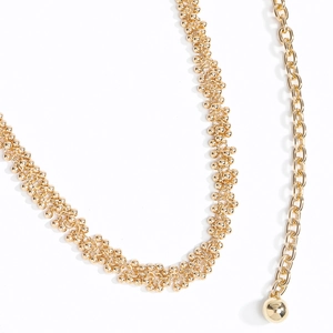 Detailaufnahme der goldenen Perlen-Taillenkette mit mehrreihigen Gliedern und kugelförmigem Anhänger