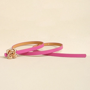 Detail of pink slim waist belt featuring a decorative golden rose-shaped metal buckle