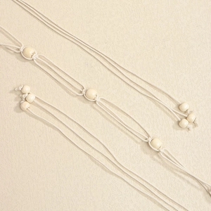 Detail of bohemian hand-woven cotton cord with round wooden beads and knot craft