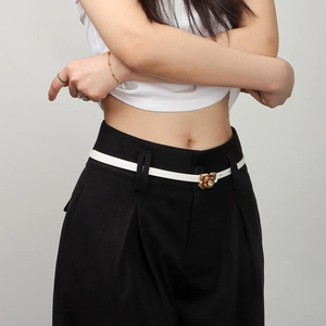 Detail of elegant white skinny belt with a gold rose buckle on a female model