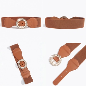 Dettaglio della cintura elastica marrone con fibbia decorata con perle e strass