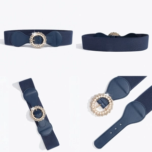 Dettaglio della cintura elastica blu navy con fibbia dorata decorata con perle e strass