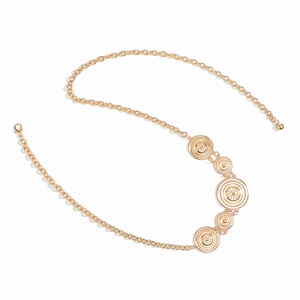 Close-up of golden vintage sun embossed medallions on a bohemian metal waist chain