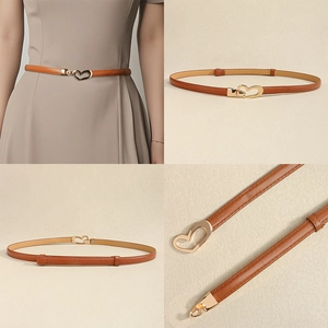 Close-up of elegant tan leather waist belt with polished gold heart buckle for dresses