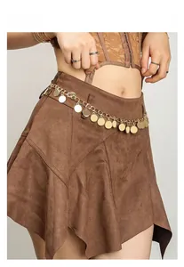 Détail d'une chaîne de taille vintage à pièces dorées sur une jupe en daim marron asymétrique