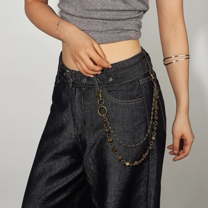 Chaîne de pantalon vintage en bronze avec dés et fermoir à ressort sur un jean