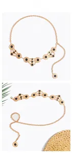 Detail of bohemian gold waist chain with black beads and textured sunburst metal discs