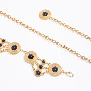 Detail of bohemian gold waist chain with black gemstone accents and lobster clasp