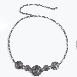 Detail view of vintage boho metal chain belt with circular relief sun charms and lobster clasp