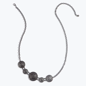 Detail of vintage bohemian metal waist chain with sun motif sunburst relief patterns