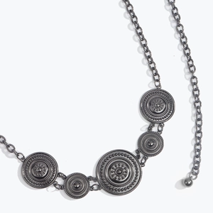Detail of vintage gun-black metal chain belt with engraved sunburst coin pendants