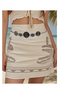 Bohemian sun-patterned vintage silver metal waist chain styled on a model at the beach