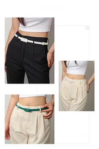 Détails de ceintures fines en blanc et vert portées avec des pantalons chics