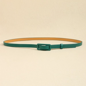 Gros plan d'une ceinture fine en cuir vert foncé avec boucle rectangulaire gainée assortie