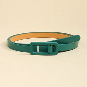 Détail d'une fine ceinture en cuir vert foncé avec boucle rectangulaire et texture de litchi