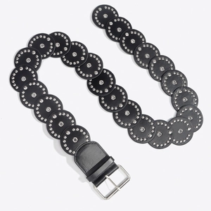 Detail view of black punk belt with overlapping round leather pieces and silver metal rivets