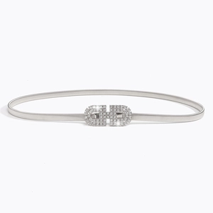 Détail d'une ceinture élastique argentée avec boucle double anneau ornée de strass brillants