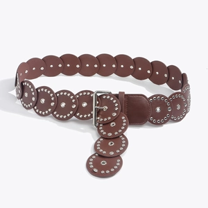 Detail of vintage brown western belt featuring round leather patches and silver rivets