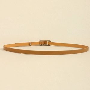 Détail d'une fine ceinture en cuir camel avec une boucle rectangulaire argentée classique