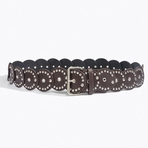 Detail of round studded leather pieces on Western vintage belt with silver buckle
