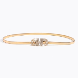 Détail d'une ceinture dorée élastique avec boucle en strass double D étincelante