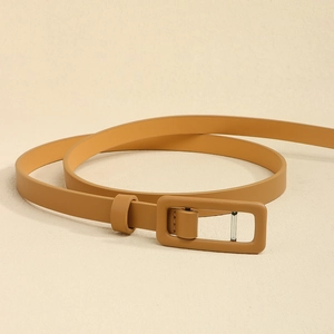 Détail de la ceinture fine en cuir gingembre avec boucle rectangulaire assortie et texture mate