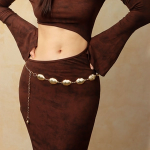 Detail view of oval textured metal chain belt on a dress featuring an adjustable extender