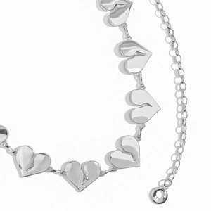 Dettaglio della cintura a catena a cuore argento punk con design a crepe e maglie metalliche