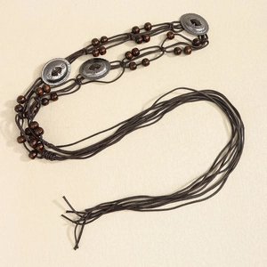 Close-up of bohemian waist chain with brown wooden beads and vintage silver metal disks