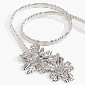 Dettaglio cintura elastica in metallo argento con fibbia a doppio fiore di girasole