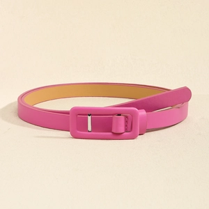 Détail d'une ceinture fine rose fuchsia avec boucle rectangulaire assortie et texture en cuir fin