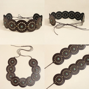 Detail of bohemian leather belt featuring turquoise inlays and metal rivet circles