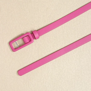 Détail d'une ceinture fine en cuir rose avec une boucle carrée recouverte assortie