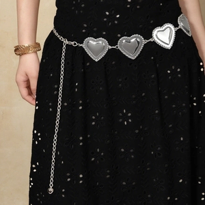 Détail de la chaîne de taille coeur argentée avec strass sur jupe brodée noire