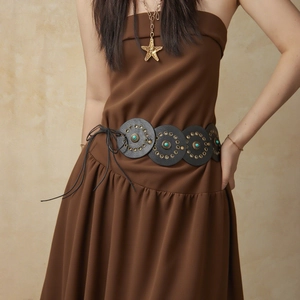 Detail of vintage belt with black leather discs, turquoise stones, and brass rivets