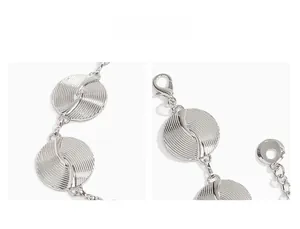 Detailed close-up of silver metal waist chain with lobster clasp and textured disk detail