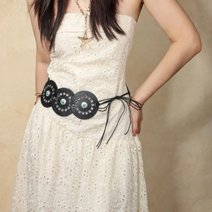 Detail view of ethnic waist belt with black leather discs, turquoise beads and metal eyelets