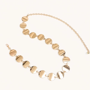 Close-up of golden geometric metal waist chain with round discs and adjustable lobster clasp
