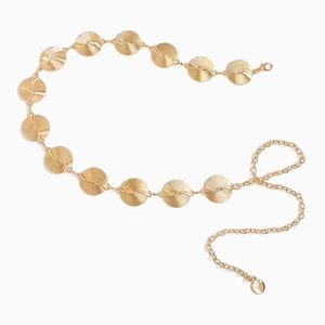Close-up of golden metal waist chain with textured round plates and adjustable lobster clasp