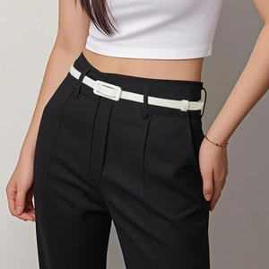 Ceinture fine blanche minimaliste avec boucle rectangulaire sur un pantalon noir