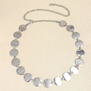 Detailed view of adjustable silver metal chain belt with polished circular plates and lobster clasp