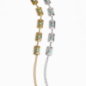 Detail of vintage metal chain belts in gold and silver with turquoise stone inlay and engravings