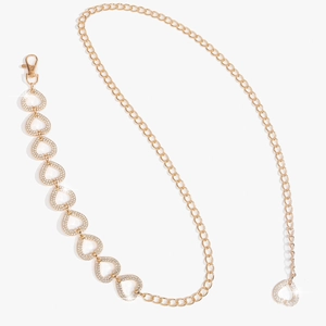 Détail de la ceinture chaîne dorée à strass en forme de cœur avec fermoir mousqueton