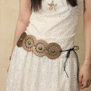 Detail of vintage bronze medallions with turquoise beads on a bohemian style waist belt