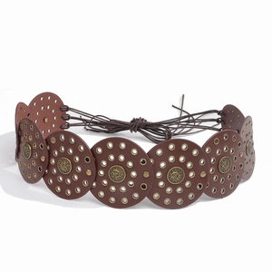 Detail of western style brown belt featuring braided round leather disks and metal eyelets